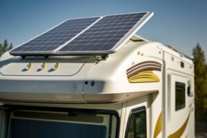Oberer Teil, horizontal gesehen, eines Wohhmobils, auf dem vorne über dem Fahrerhaus ein mobiles Solarpanel geneigt befestigt ist